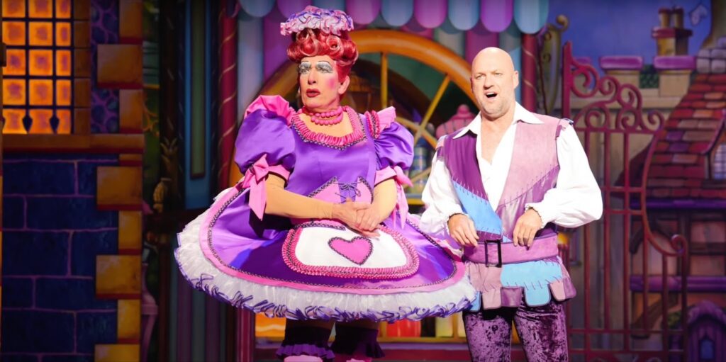A man and a woman in colorful costumes perform on stage