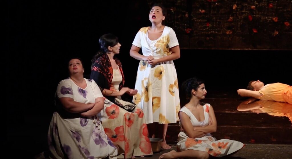 Group of women singing on stage in theater