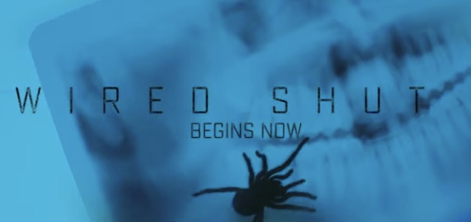 Text reading 'WIRED SHUT BEGINS NOW' on a blue background with a silhouette of a spider