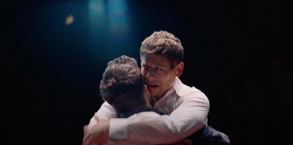 Two men hugging on stage, close-up