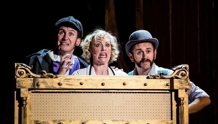 Two men and a woman play on stage in the theater