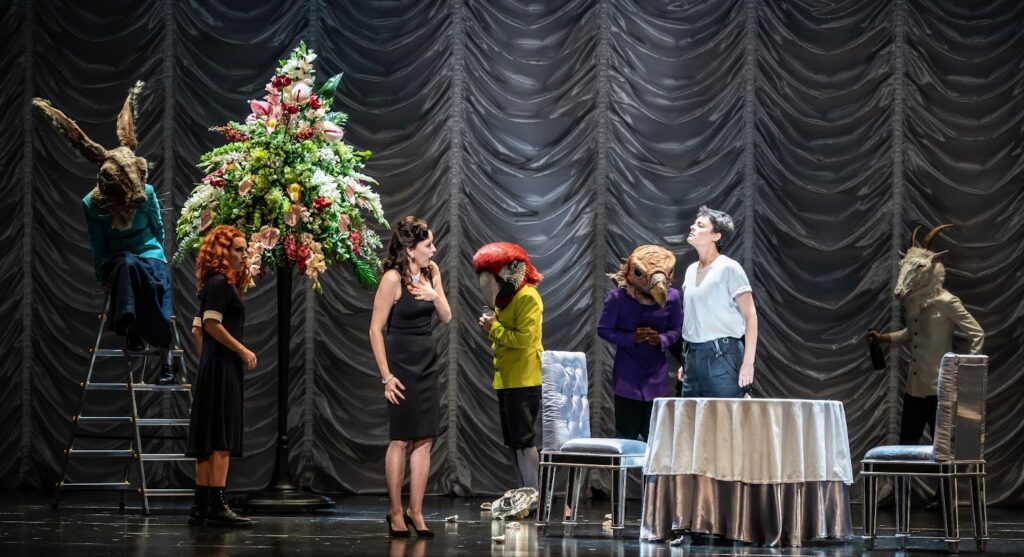 A group of people play on stage among the scenery
