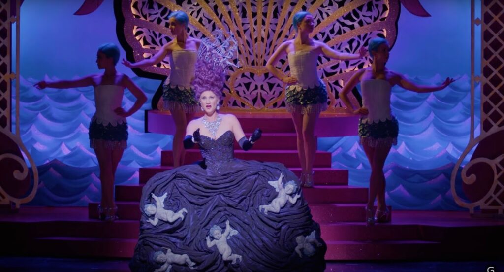 Woman in colorful dress sings on stage