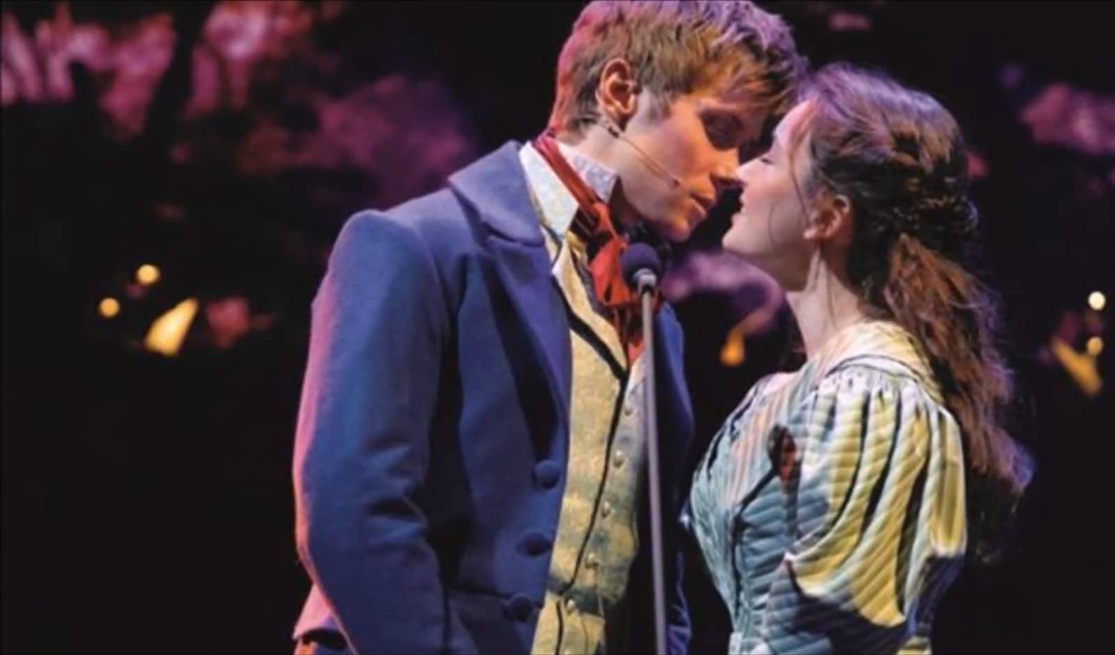 man and woman kissing and standing on the theatre stage
